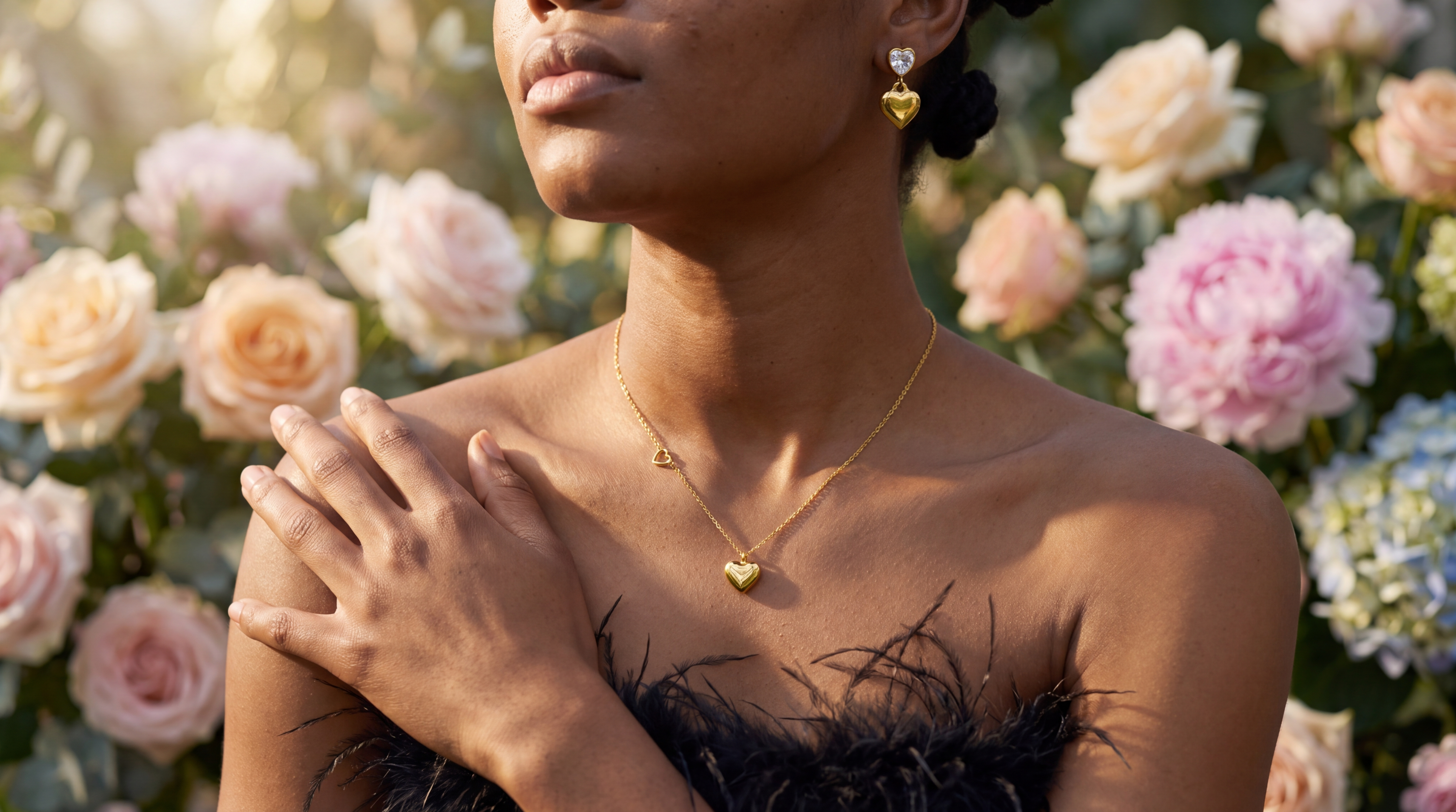 Woman in a flower garden wearing a gold heart pendant necklace and heart earrings
